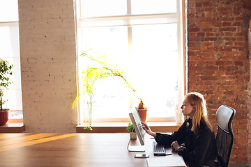 Image showing Caucasian young woman in business attire working in office