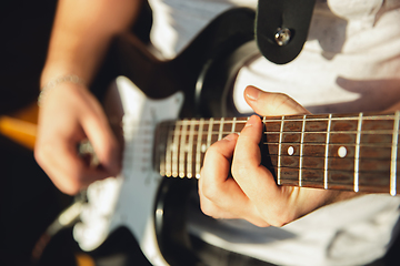 Image showing Caucasian musician playing guitar during online concert at home isolated and quarantined, impressive improvising, close up