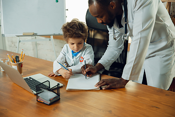 Image showing Little caucasian boy as a doctor consulting for patient, working in cabinet, close up