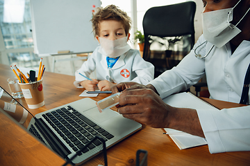 Image showing Little caucasian boy as a doctor consulting for patient, working in cabinet, close up