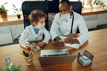 Image showing Little caucasian boy as a doctor consulting for patient, working in cabinet, close up