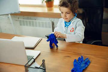 Image showing Little caucasian boy as a doctor consulting for patient, working in cabinet, close up