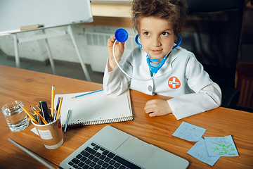 Image showing Little caucasian boy as a doctor consulting for patient, working in cabinet, close up