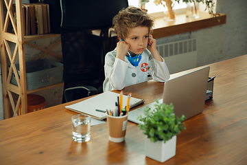 Image showing Little caucasian boy as a doctor consulting for patient, working in cabinet, close up