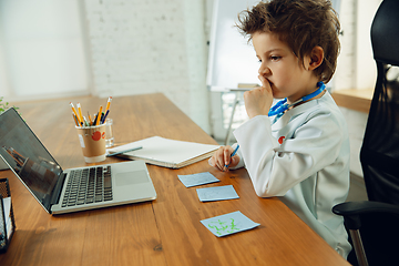 Image showing Little caucasian boy as a doctor consulting for patient, working in cabinet, close up