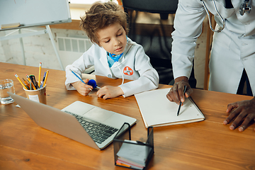 Image showing Little caucasian boy as a doctor consulting for patient, working in cabinet, close up