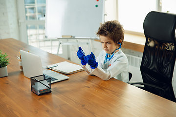 Image showing Little caucasian boy as a doctor consulting for patient, working in cabinet, close up