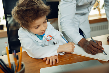 Image showing Little caucasian boy as a doctor consulting for patient, working in cabinet, close up