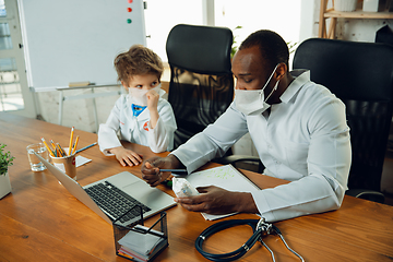 Image showing Little caucasian boy as a doctor consulting for patient, working in cabinet, close up