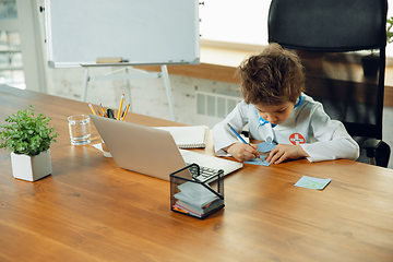 Image showing Little caucasian boy as a doctor consulting for patient, working in cabinet, close up