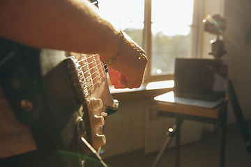 Image showing Caucasian musician playing guitar during online concert at home isolated and quarantined, impressive improvising, close up