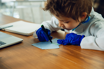 Image showing Little caucasian boy as a doctor consulting for patient, working in cabinet, close up