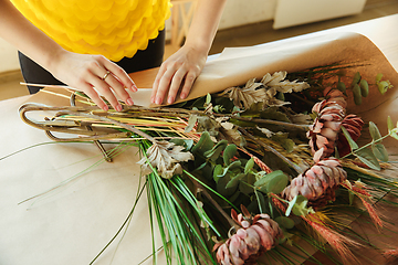 Image showing Florist at work: woman shows how to make bouquet, working at home concept, close up