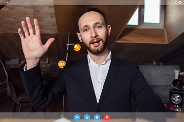 Image showing Young man talking, working in videoconference with co-workers at office or living room. Online business, education during quarantine.