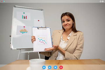 Image showing Young woman talking, working in videoconference with co-workers at office or living room. Online business, education during quarantine.