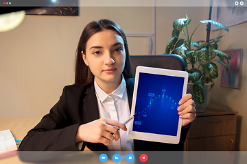 Image showing Young woman talking, working in videoconference with co-workers at office or living room. Online business, education during quarantine.