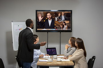 Image showing Young colleagues talking, working in videoconference with co-workers at office or living room. Online business, education during quarantine.