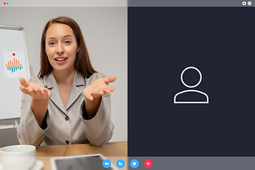 Image showing Young woman talking, working in videoconference with co-workers at office or living room. Online business, education during quarantine.