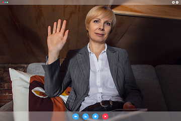 Image showing Young woman talking, working in videoconference with co-workers at office or living room. Online business, education during quarantine.