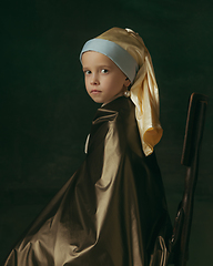 Image showing Medieval little girl as a lady with a pearl earring on dark studio background. Concept of comparison of eras, childhood. Stylish creative design, art vision, new look of artwork.