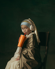 Image showing Medieval little girl as a lady with a pearl earring on dark studio background. Concept of comparison of eras, childhood. Stylish creative design, art vision, new look of artwork.