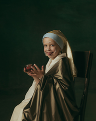 Image showing Medieval little girl as a lady with a pearl earring on dark studio background. Concept of comparison of eras, childhood. Stylish creative design, art vision, new look of artwork.