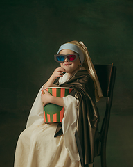 Image showing Medieval little girl as a lady with a pearl earring on dark studio background. Concept of comparison of eras, childhood. Stylish creative design, art vision, new look of artwork.