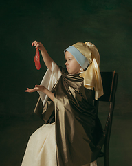 Image showing Medieval little girl as a lady with a pearl earring on dark studio background. Concept of comparison of eras, childhood. Stylish creative design, art vision, new look of artwork.