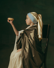 Image showing Medieval little girl as a lady with a pearl earring on dark studio background. Concept of comparison of eras, childhood. Stylish creative design, art vision, new look of artwork.