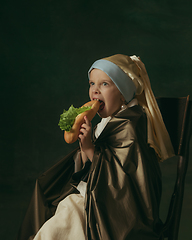 Image showing Medieval little girl as a lady with a pearl earring on dark studio background. Concept of comparison of eras, childhood. Stylish creative design, art vision, new look of artwork.