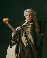 Image showing Medieval little girl as a lady with a pearl earring on dark studio background. Concept of comparison of eras, childhood. Stylish creative design, art vision, new look of artwork.