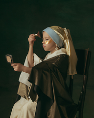 Image showing Medieval little girl as a lady with a pearl earring on dark studio background. Concept of comparison of eras, childhood. Stylish creative design, art vision, new look of artwork.