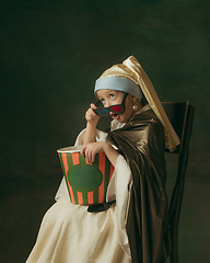 Image showing Medieval little girl as a lady with a pearl earring on dark studio background. Concept of comparison of eras, childhood. Stylish creative design, art vision, new look of artwork.