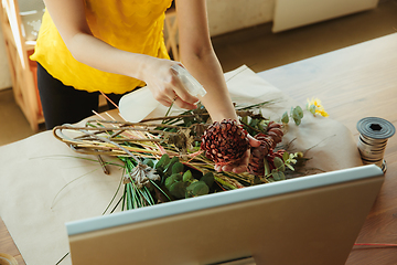 Image showing Florist at work: woman shows how to make bouquet, working at home concept, close up