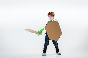 Image showing Little caucasian boy as a warrior in fight with coronavirus pandemic, with a shield, a sword and a toilet paper bandoleer, protecting