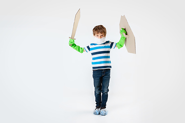 Image showing Little caucasian boy as a warrior in fight with coronavirus pandemic, with a shield, a sword and a toilet paper bandoleer, attacking