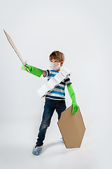 Image showing Little caucasian boy as a warrior in fight with coronavirus pandemic, with a shield, a sword and a toilet paper bandoleer, attacking