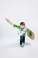 Image showing Little caucasian boy as a warrior in fight with coronavirus pandemic, with a shield, a sword and a toilet paper bandoleer, attacking