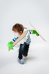 Image showing Little caucasian boy as a warrior in fight with coronavirus pandemic, with a shield, a sword and a toilet paper bandoleer, attacking