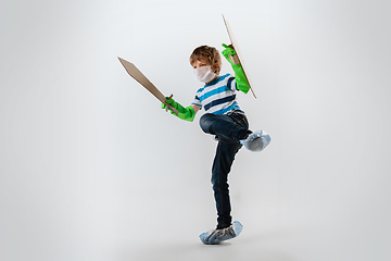 Image showing Little caucasian boy as a warrior in fight with coronavirus pandemic, with a shield and sword, attacking