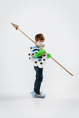 Image showing Little caucasian boy as a warrior in fight with coronavirus pandemic, with a face mask, a spear and a toilet paper bandoleer, attacking