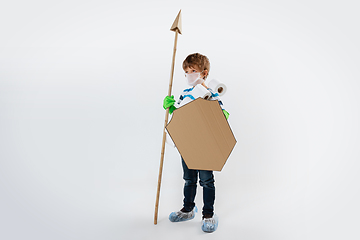 Image showing Little caucasian boy as a warrior in fight with coronavirus pandemic, with a shield, a spear and a toilet paper bandoleer, attacking