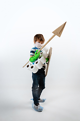 Image showing Little caucasian boy as a warrior in fight with coronavirus pandemic, with a shield, a spear and a toilet paper bandoleer, attacking