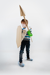 Image showing Little caucasian boy as a warrior in fight with coronavirus pandemic, with a shield, a spear and a toilet paper bandoleer, attacking