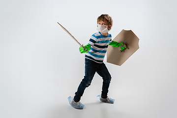 Image showing Little caucasian boy as a warrior in fight with coronavirus pandemic, with a shield, a sword and a toilet paper bandoleer, protecting