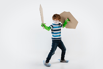 Image showing Little caucasian boy as a warrior in fight with coronavirus pandemic, with a shield, a sword and a toilet paper bandoleer, protecting