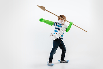 Image showing Little caucasian boy as a warrior in fight with coronavirus pandemic, with a face mask, a spear and a toilet paper bandoleer, attacking