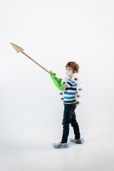 Image showing Little caucasian boy as a warrior in fight with coronavirus pandemic, with a face mask, a spear and a toilet paper bandoleer, attacking