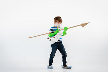 Image showing Little caucasian boy as a warrior in fight with coronavirus pandemic, with a face mask, a spear and a toilet paper bandoleer, attacking