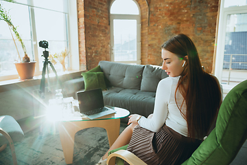 Image showing Caucasian woman singing during online concert at home isolated and quarantined, impressive improvising, dancing